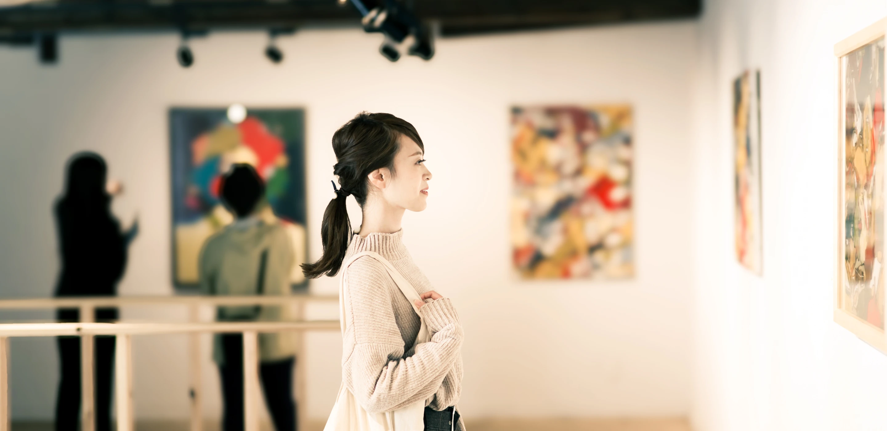 美術展で展示品を鑑賞する人の写真