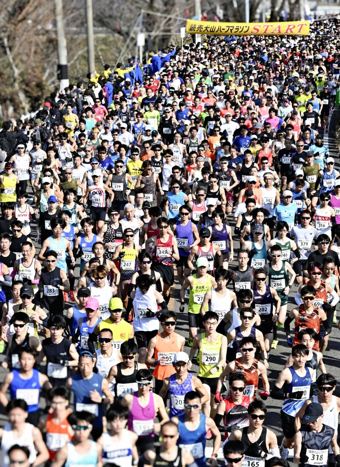 号砲とともに一斉に駆け出す犬山ハーフマラソンのランナーの写真